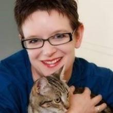 Dr Trepheena Hunter smiles at camera whilst hugging her cat
